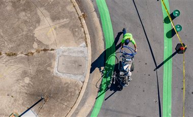 Road Marking Machines & Accessories Aerial view of a worker painting a green lane with a road marking machine